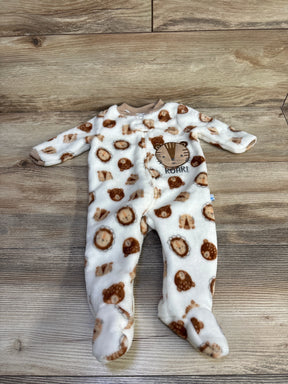 Flat lay of white plush footed baby sleeper with brown lion faces and embroidered ROAR patch zip front on light wood