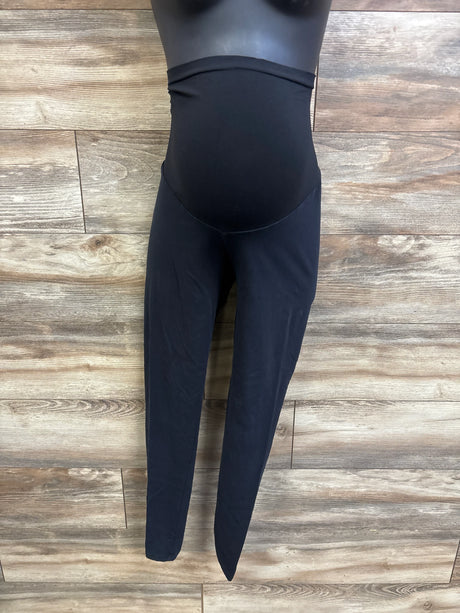 Front view of black maternity full-panel leggings showing full belly panel on mannequin against wood-plank background