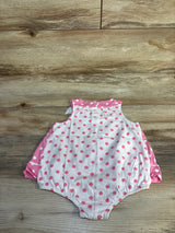 Flat lay of polka dot baby bubble bodysuit dress showcasing bow detail and elastic leg openings on wood plank background