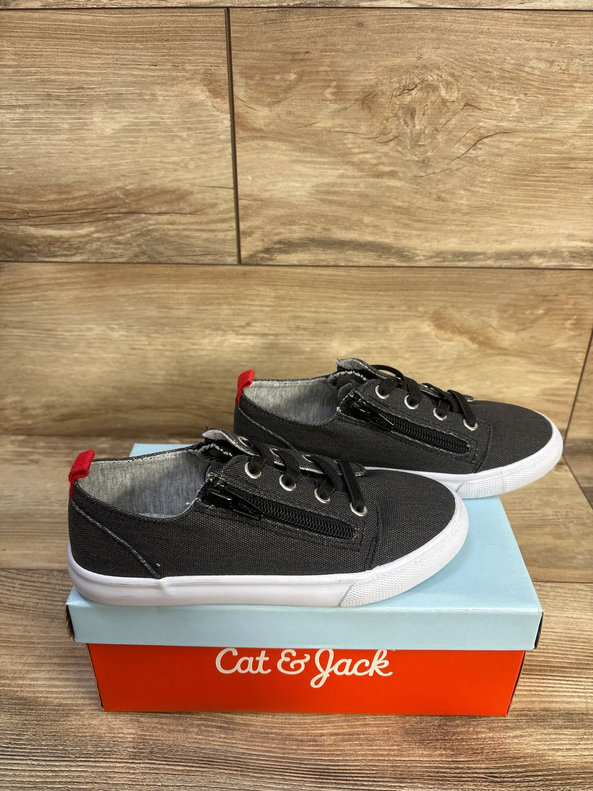 Side view of Cat & Jack toddler grey canvas sneakers with double zippers, black laces, white rubber sole on Cat & Jack shoebox