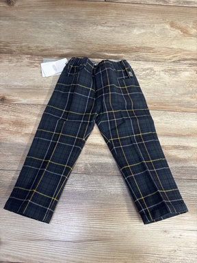 Kids black plaid pants with yellow and white stripes on wooden background