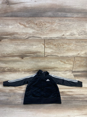 Front view of black Adidas toddler full-zip track jacket showing white three stripes on sleeves, chest logo, zip pockets on wood background