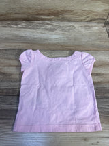 Light pink Janie & Jack baby top for sizes 6-12m on a wood background