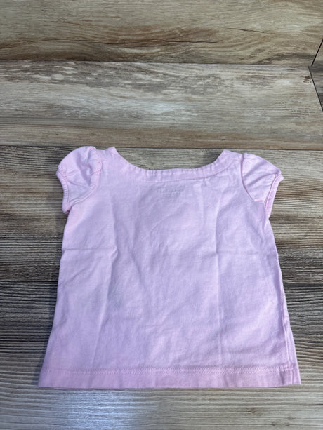 Light pink Janie & Jack baby top for sizes 6-12m on a wood background