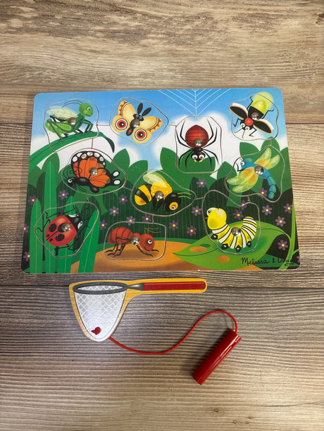 Top view of Melissa & Doug magnetic wooden bug-catching puzzle game with insect pieces and catching net on a wood table