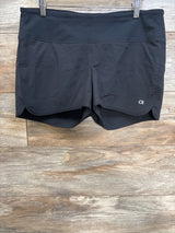 Front view of GapFit maternity running shorts showing wide foldover waistband, curved hem and built-in liner on wood background