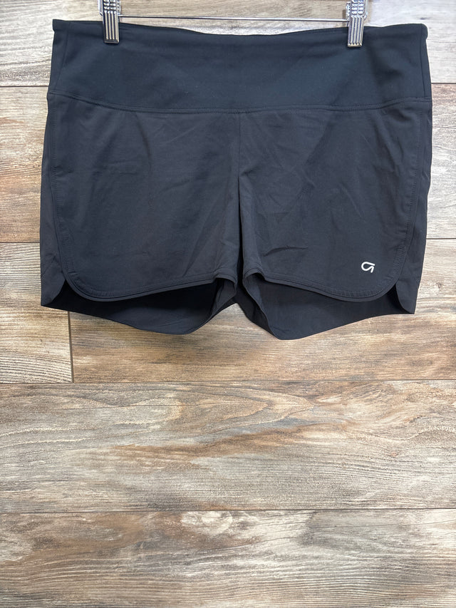 Front view of GapFit maternity running shorts showing wide foldover waistband, curved hem and built-in liner on wood background