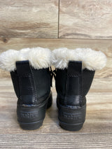Black kids' winter boots with faux fur lining and Native branding, on wood floor