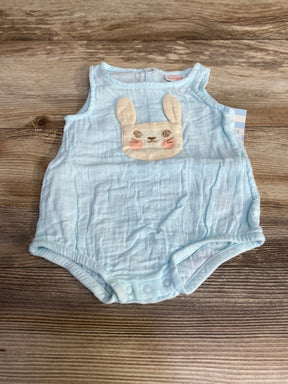 Front view of Cat and Jack light blue gauze baby romper showcasing embroidered bunny applique and three snap crotch closures on wood background