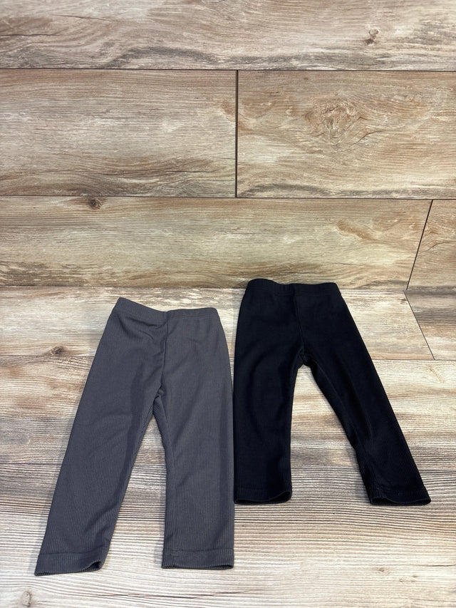 Front view of two black ribbed baby leggings (9-12 months) showing ribbed knit texture on white background