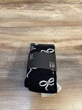 Black Baby Gap tights for toddler girl, age 4-5 years, with white bow pattern, new with tags on wood floor