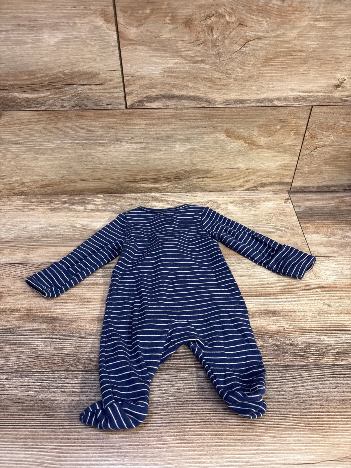 Front view of Just One You newborn sleeper showcasing long sleeves, footed legs, and white stripes on blue fabric