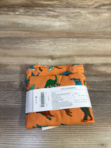 Front view of orange 2-piece baby pajama set with skateboarding dinosaur print on top and matching pants on white background