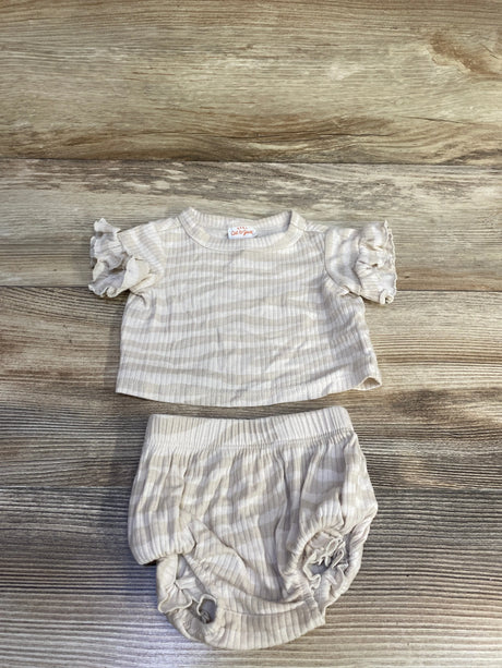 Top-down view of ivory newborn ribbed two-piece: short-sleeve ruffle shirt and bloomers showing ribbed texture on wood background