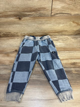 Kids blue and gray checkered jogger pants with drawstring and cuffed ankles on wood floor