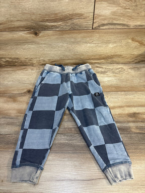 Kids blue and gray checkered jogger pants with drawstring and cuffed ankles on wood floor