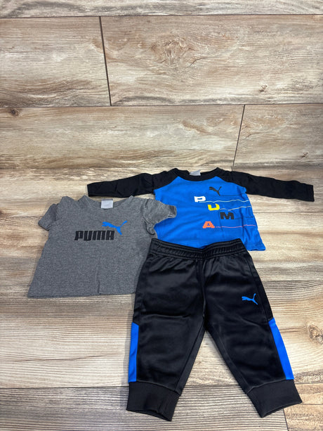 Kids Puma outfit set with blue and gray shirts and black track pants on wood floor