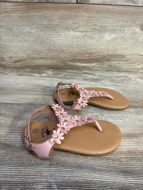 Three-quarter view of Beverly Hills Polo Club Floral Sandals Pink sz 10c showcasing pink T-strap thong sandals with daisy flower accents on wood plank floor