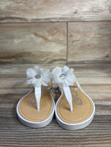 Front view of Bebe white chiffon flower sandals showing fabric flowers with rhinestone centers on wood background