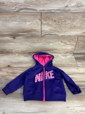 Purple Nike kids hoodie with pink zipper and logo, laid on wooden surface