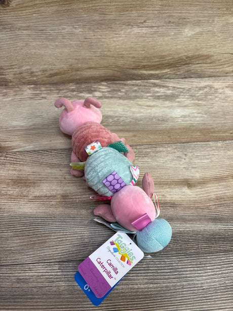 Taggies Camilla Caterpillar plush baby toy with pastel colors and sensory tags on wood background