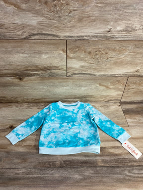 Blue and white tie dye kids long sleeve shirt on wood background with clothing tag