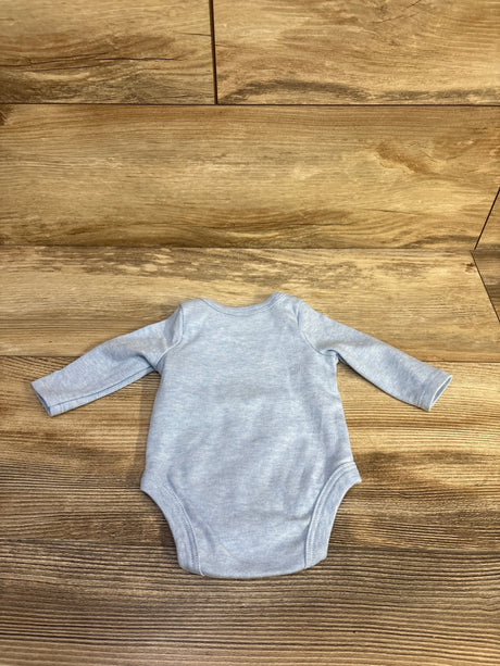 Flat lay of Sterling Baby newborn blue long-sleeve bodysuit showing back and full sleeves on wood background