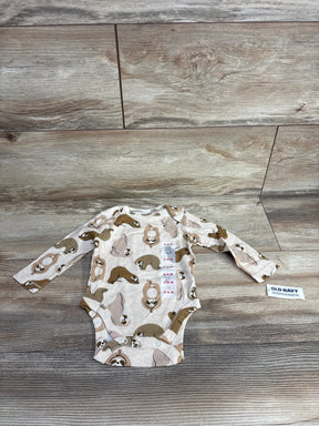 Old Navy long sleeve baby bodysuit with sloth print, size 3-6 months, laid on wood background.