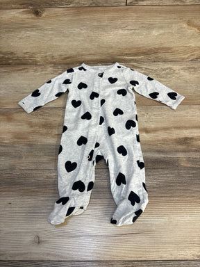 Gray baby sleeper with black heart pattern, long sleeves, button front on wood floor