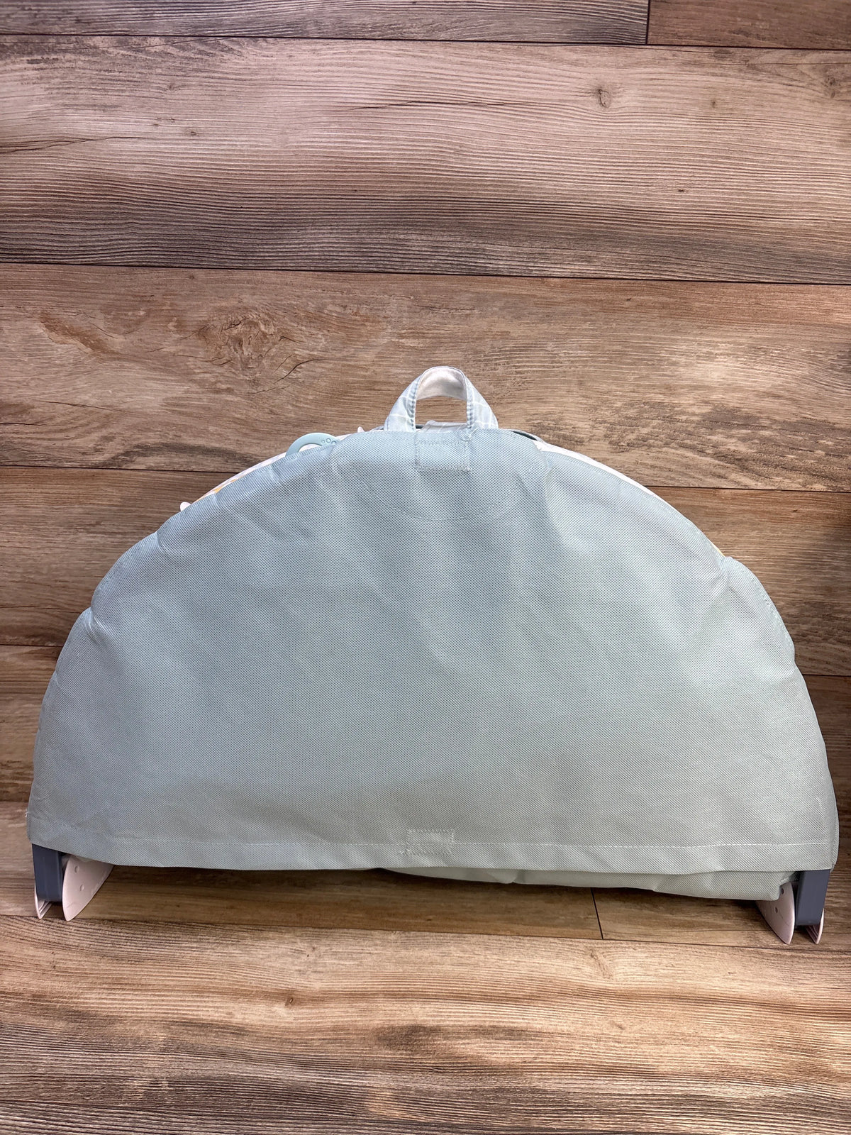 Back view of Yookidoo 3-in-1 Urban Gymotion Lay to Sit-Up Play Mat showing carry handle and support legs on a wood floor