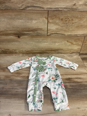 Flat lay of newborn white floral coverall with mint-green trim, two chest bows and snap-front closure on wood background