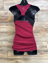 Front view of red spacedye maternity racerback tank with black crossover back and ruched sides on mannequin, wood background
