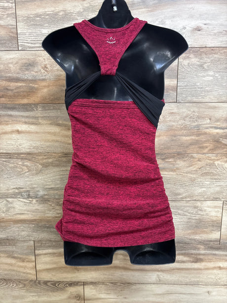 Front view of red spacedye maternity racerback tank with black crossover back and ruched sides on mannequin, wood background