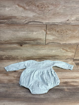 Front view of RZ by Rachel Zoe pale green romper with long sleeves and gathered waist, laid flat on wood, size 6–9m