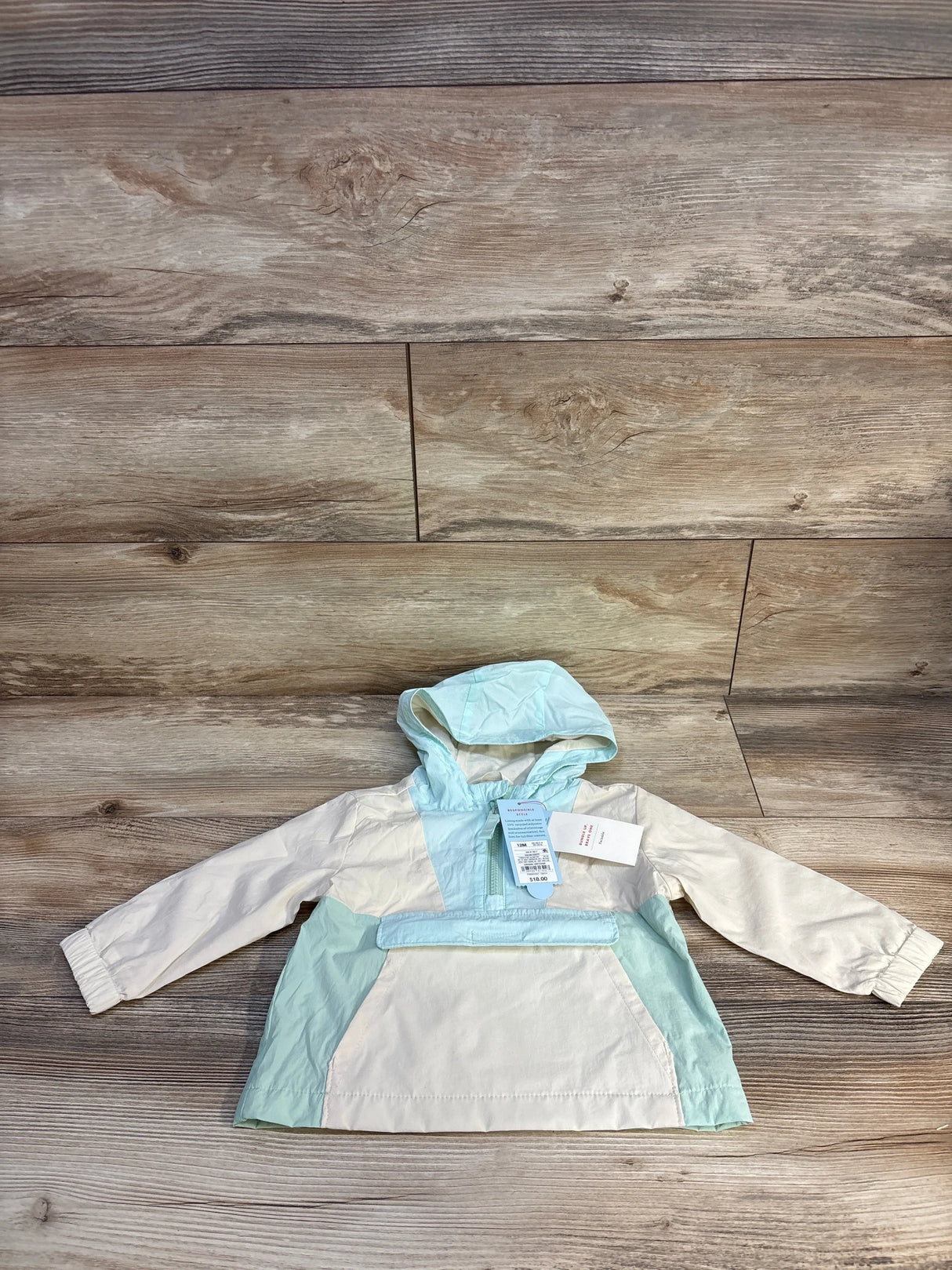 Baby mint and cream hooded raincoat for kids, lightweight and waterproof, perfect for outdoor adventures.