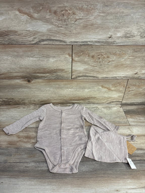 Striped long sleeve baby bodysuit and matching hat set on wood background