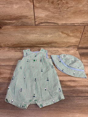 Front view of green seersucker baby romper and matching hat showing golf embroidered motifs and snap closures on wood floor