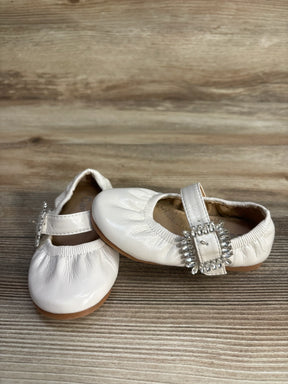White baby girl shoes with jewel buckles on wooden surface