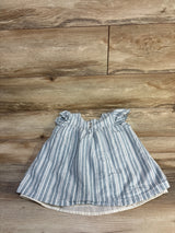 Top view of blue and white striped toddler top (size 4T) showcasing ruffled cap sleeves and front buttons on a wood plank background