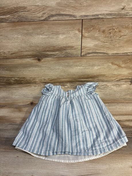 Top view of blue and white striped toddler top (size 4T) showcasing ruffled cap sleeves and front buttons on a wood plank background