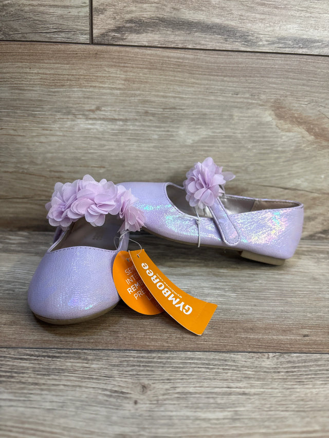 Three-quarter view of Gymboree lavender ballet flats size 9C showing glitter finish and flower straps on wood floor