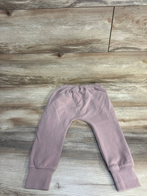 Light mauve baby leggings with cuffed ankles on wood background, children's clothing resale