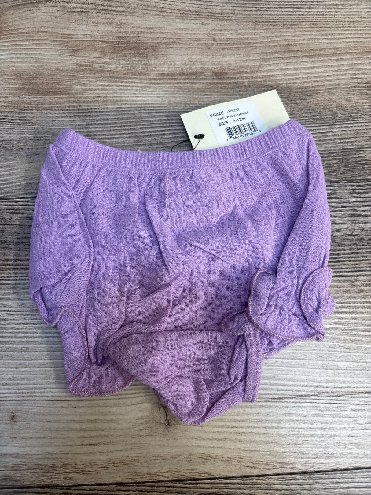 Lavender baby bloomers with tag on wood background, gently used kids clothing