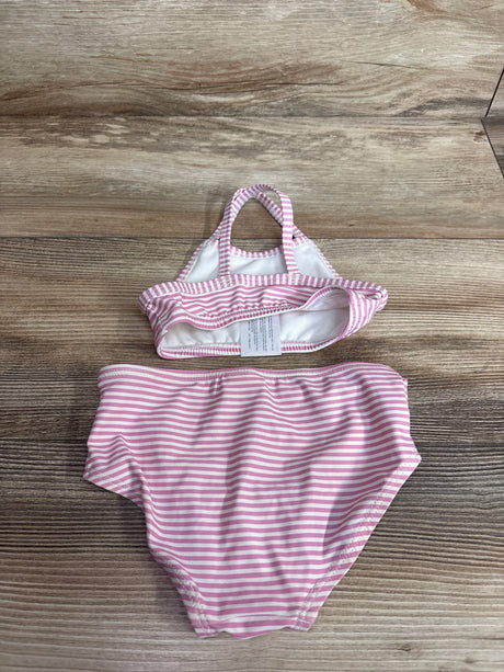 Top-down view of Carter's two-piece pink and white striped baby swimsuit showing halter-style top and high-waist bottoms on wood background