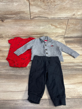 Baby boy outfit with red holiday onesie, gray cardigan, and black pants on wood floor
