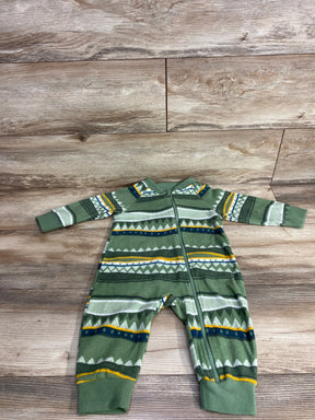 Green fleece baby onesie with geometric patterns and zipper closure on wood floor