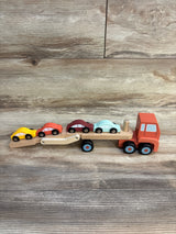 Wooden toy car carrier truck with four colorful cars on wood background