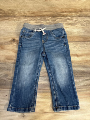 Toddler blue denim jeans with grey elastic waistband and drawstring on wood background