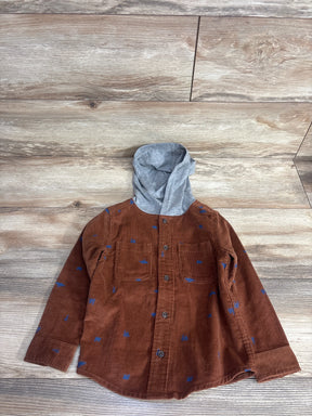 Brown corduroy kids shirt with blue spots, long sleeves, and gray hood on wood floor