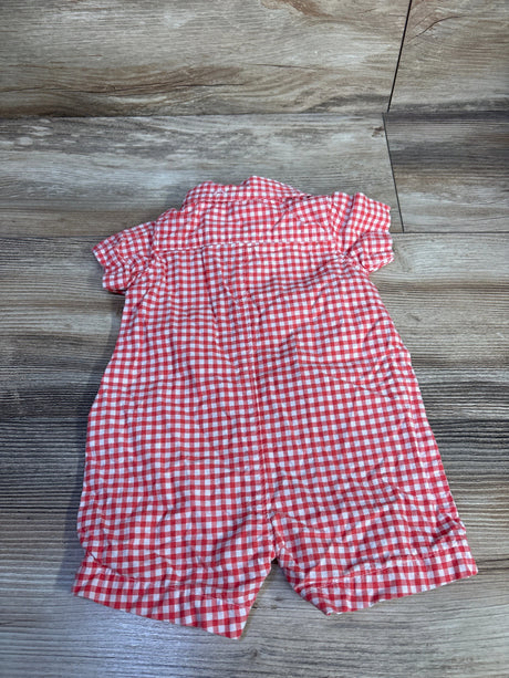 Back view of red and white gingham shortie romper showing short sleeves, collar and cuffed short legs on wood floor background